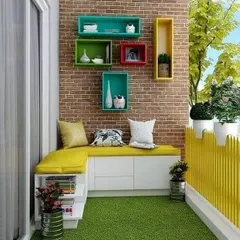 A cozy balcony makeover featuring a custom L-shaped bench with built-in storage. The design is complemented by colorful wall-mounted box shelves.