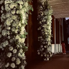 The entrance to an elegant 25th-anniversary party. We used dense arrangements of white chrysanthemums and baby's breath to create a lush, romantic floral gateway for guests as they arrived.