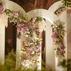 We love creating picture-perfect moments. This backdrop of layered white arches, adorned with cascading florals in soft pastel shades, served as a romantic and dreamy photo corner for guests.