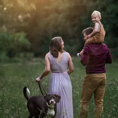 A family walk in the fields, complete with their furry friend. Including pets in family portraits adds an extra layer of warmth and personality to the images.