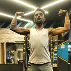 A clear shot of my bicep and shoulder definition in the gym. This level of lean muscle is achieved by carefully balancing calorie intake and expenditure, a core principle of my nutrition coaching.