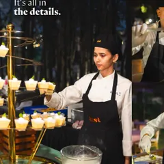 A chef carefully arranges mini dessert cups on a multi-tiered display stand.
