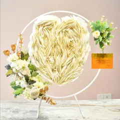 This is one of my specialty designs, a gravity-defying floating heart cake. The heart-shaped cake appears to float in mid-air, supported by a delicate stand and adorned with elegant white feathering and floral arrangements, creating a truly magical and unforgettable showstopper for any celebration.