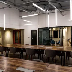 A different perspective of the sculptural lighting installation. Notice how the light is bright enough for tasks but diffused to prevent harsh shadows or glare on screens, which is crucial for a comfortable working environment.