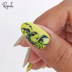 A close-up of a bold swirl design on a client's nail. The neon yellow and black make a powerful statement.