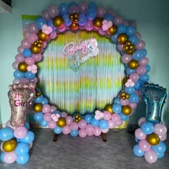Celebrate the mom-to-be with a beautiful baby shower. This popular gender-reveal setup uses a full balloon ring in pink, blue, and gold, with "It's a Girl" and "It's a Boy" accents, all centered around a shimmering backdrop and a "Baby Shower" neon sign.