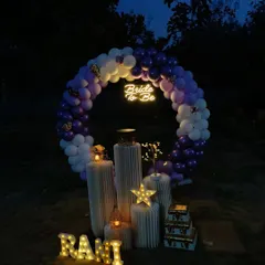 This is a more atmospheric view of the outdoor 'Bride to be' setup, captured just as night falls. The glow from the neon sign, marquee letters, and decorative stars creates a captivating and intimate feel for a special evening celebration.