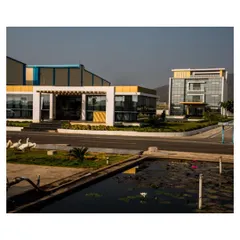 This perspective highlights the different structures within the Krishna Sai Granites industrial park. Our design ensures that even functional buildings contribute to a cohesive and professional campus aesthetic, complete with thoughtful landscaping and water elements.