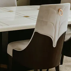 A close-up of the dining chair, revealing the leaf-like stitching on the back and the elegant metal ring pull. These small details are what elevate the design and add a touch of luxury.
