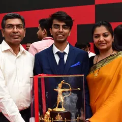 A portrait of our shooter Srijay with his parents and the Ekalavya Award. Family support is a cornerstone of our athletes' success.