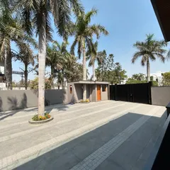 The driveway at Gulmohar Farmhouse was designed to accommodate several mature palm trees. By paving around them, we preserved the site's established greenery and created a grand, tree-lined entrance.
