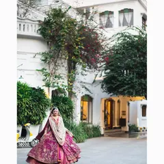 A beautiful bridal twirl. The bride's magnificent magenta lehenga is on full display against the classic architecture of the venue.