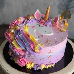 A magical unicorn cake that's always a hit with the little ones. This design features a rainbow of buttercream swirls, a golden horn, and a sprinkle of edible glitter.