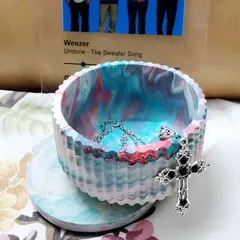 This is our Aurora bowl, a custom piece we made for a client. The swirling blend of colors was inspired by the northern lights. It's shown here being used as a jewelry holder.