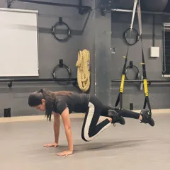 A TRX-assisted mountain climber, a challenging exercise that targets the core, shoulders, and legs all at once.