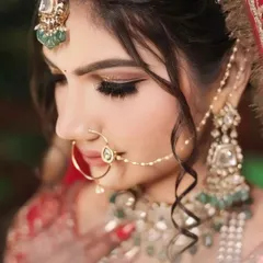 A close up portrait of the bride, focusing on her stunning jewelry and flawless makeup. Every detail, from the emeralds to the winged eyeliner, is captured perfectly.