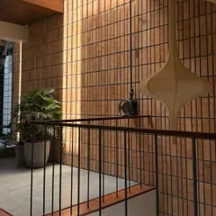 Sunlight grazes a wall of vertically laid bricks, highlighting the rich texture and color variations of the material.