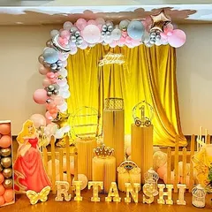 A charming Disney Princess themed birthday decoration. The setup includes cutouts of Princess Aurora and Snow White, a golden backdrop, and a pink and silver balloon arch for a royal celebration.