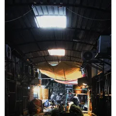 A look down a narrow, dimly lit alleyway in the flower market. We play with light and shadow to create a sense of depth and mystery, drawing the viewer into the hidden corners of the city.