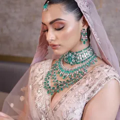 The beauty of a pastel bridal look lies in its subtlety. Here, I've used soft pinks and a luminous highlight to create a fresh, dewy look that complements the delicate embroidery and emerald jewellery.