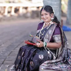 A smiling portrait showcasing the full set of sugar jewellery, including the necklace, earrings, and maang tikka.