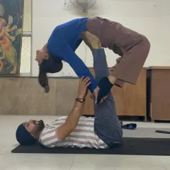 A classic Acro Yoga pose, the 'back bird', which helps open the chest and spine for the flyer. As the base, I ensure stability and support throughout the posture.