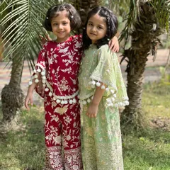 Sisterly love in full bloom. I designed these matching cape sets in rich maroon and soft pistachio green, complete with playful pom-pom details for a touch of whimsy.
