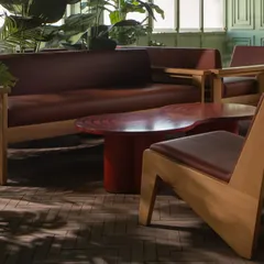 In this green-toned private lounge, I used custom-designed wooden furniture with clean, angular lines and rich brown leather. The space is filled with dappled light from nearby windows, creating a calm and earthy retreat with a mid-century modern sensibility.