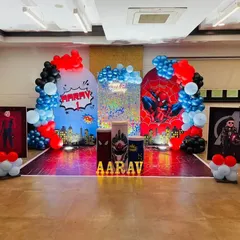 A full-blown Spiderman and Avengers-themed birthday for Aarav. The backdrop features a city skyline, Spiderman graphics, and balloon arches in the hero's signature red and blue colors.