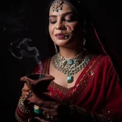 I love using creative lighting to create a mood. Here, a simple diya adds a divine glow, highlighting the bride's features and creating a serene, almost spiritual portrait.