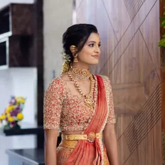 A side profile showcasing the intricate hairstyle and beautiful gold jewellery.