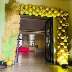 I design impressive entrance arches for larger events and functions. This particular arch combines a full structure of golden balloons with decorative elements made from dried palm leaves, creating a grand and unique entryway for guests.