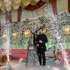 A picture-perfect couple entry. The bride and groom stand amidst a cloud of smoke and sparkling cold pyros, creating a dreamy and romantic photo opportunity.