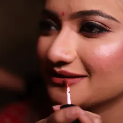 Applying lipstick is one of the final, transformative steps. I use a precise brush to ensure a perfectly defined and long-lasting lip.