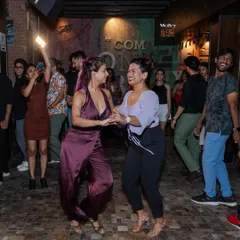 Two dancers sharing a smile and a great dance at our weekly social. It is all about connecting with others who share your passion for Latin dance.