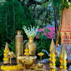 A close-up of the traditional decor elements. We use authentic brass urlis, lamps, and other props, decorated with fresh flowers, to create an auspicious setting.