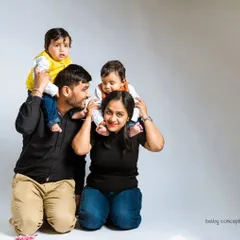 A playful family photo with twin boys enjoying a shoulder ride. I always make sure to include fun, interactive poses that capture the energy of your family.