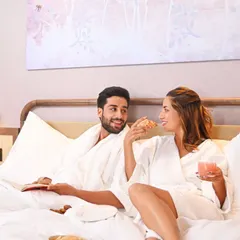 Romance and relaxation go hand in hand. A couple enjoys breakfast in bed in one of our luxurious rooms, a perfect start to a day of connection and indulgence.