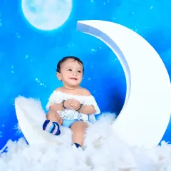 Over the moon with this dreamy setup! I use a crescent moon prop, fluffy clouds, and a starry blue backdrop to create a magical, celestial scene for your little star.