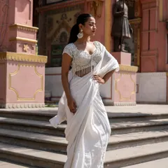 A closer look at our stunning ivory pre-draped saree with a fully beaded tassel blouse. It's a modern, high-fashion take on the classic white saree.
