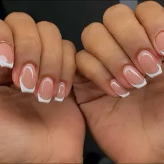 A timeless classic executed to perfection. This image shows a beautiful, clean French manicure with perfectly shaped square tips and a glossy finish.