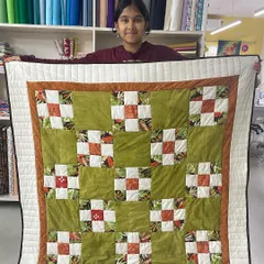 It’s a joy to see our youngest creators shine. Here, 12-year-old Shresta proudly displays her very first quilt, a beautiful patchwork project she completed in our kids' sewing workshop.