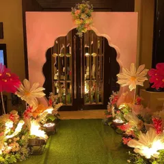 We created a magical entrance for the cradle ceremony, lining a green turf walkway with oversized, illuminated paper flowers and leading to a grand, floral-adorned archway.