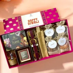 A closer look at the premium Diwali hamper, showcasing the rich textures and vibrant colors. It includes Smoor luxe chocolates, a silver Lakshmi ji frame, a lavender reed diffuser, and small jute potlis filled with assorted dry fruits.