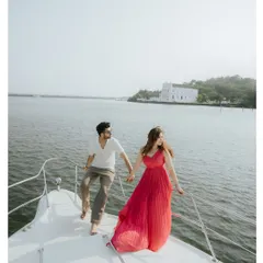 A carefree moment on a private yacht in Goa. This shot captures the spirit of a luxury coastal escape, with the bride's flowing red dress adding a splash of color against the serene waters.