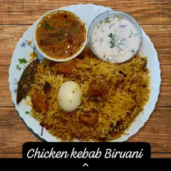 For those who love extra spice and crunch, I offer this Chicken Kebab Biryani. Juicy pieces of chicken kebab are layered with fragrant basmati rice, served with salan and raita for a complete meal.