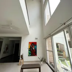 The double-height ceiling in our main hall is an architectural highlight, allowing for the display of large vertical paintings that command attention. It creates a sense of scale and openness throughout the gallery.