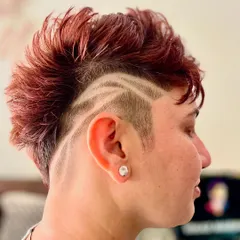A close-up of the hair tattoo, combined with a textured mohawk. The red-brown color adds another layer of dimension to this bold and creative style.