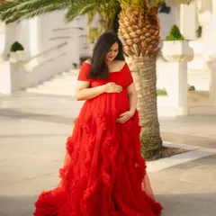A quiet moment of reflection. The mom-to-be looks down at her bump with so much love, framed by a beautiful palm tree and bathed in the warm glow of the Dubai sun.