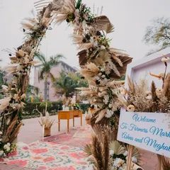 The entrance to a 'Farmer's Market' themed event, featuring a rustic arch of pampas grass and dried palms. This unique theme was a nod to the couple's story.